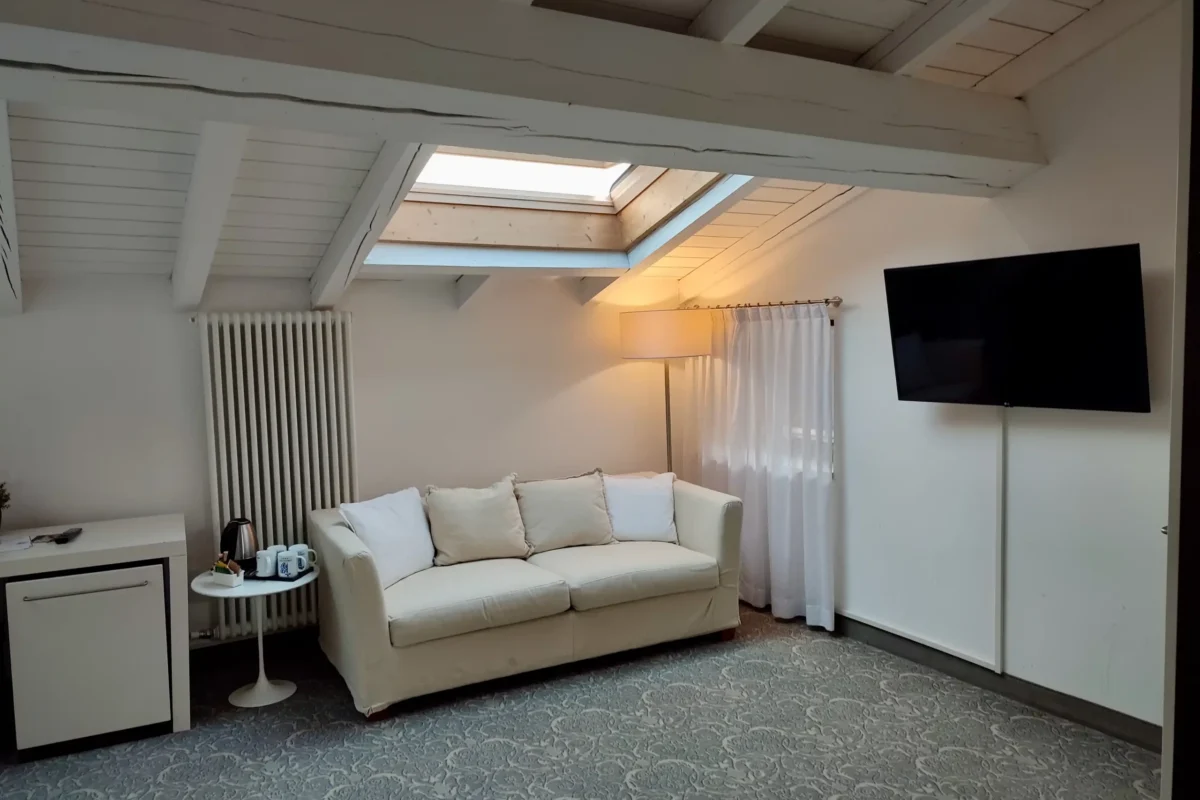 Zona living con divano e TV della Junior Suite, Hotel Accademia Trento