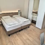 Camera da letto con letti e armadio del Bilocale, Hotel Accademia Trento
