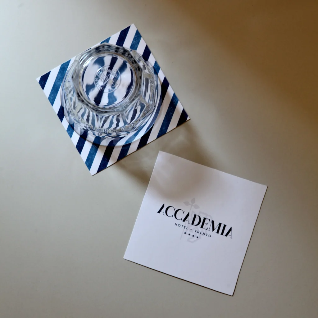 Logo Hotel Accademia Trento su card e sottobicchiere