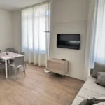 Soggiorno con Smart TV e divano del Trilocale, Hotel Accademia Trento