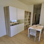 Soggiorno con libreria del Trilocale, Hotel Accademia Trento appartamento di pregio