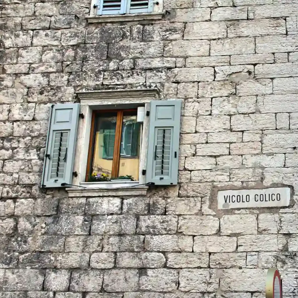 Vicolo Colico nel centro storico di Trento con finestra aperta